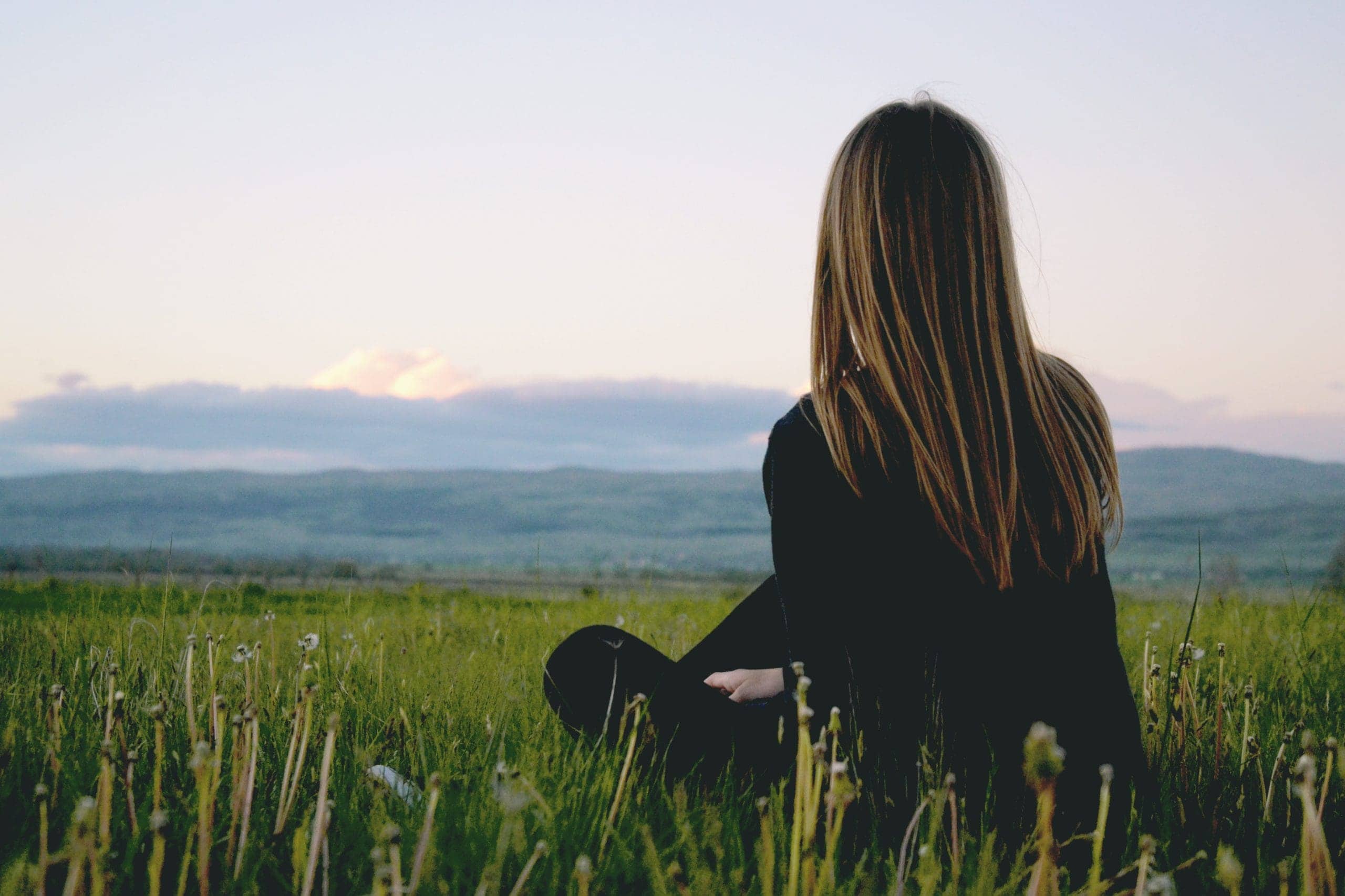 serene nature landscape with a person sitting or lying down, appearing to be relaxed and at peace